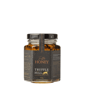 A hexagonal glass jar with a black label branded Truffle Hill. Label describes Truffle Honey