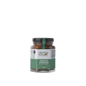A hexagonal glass jar with a black label branded Truffle Hill. Label describes Truffle Tapenade